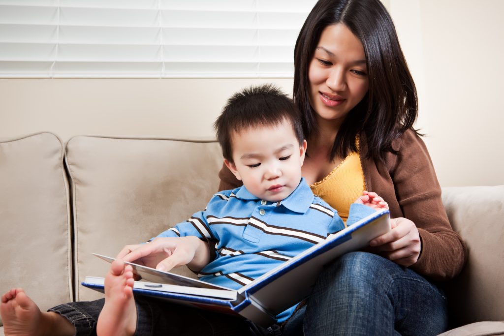 A portrait of a mother and a son reading a book