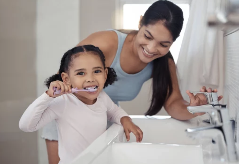 Mother assisting child in oral care