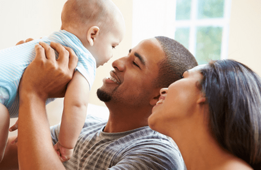 Man lifting baby with woman